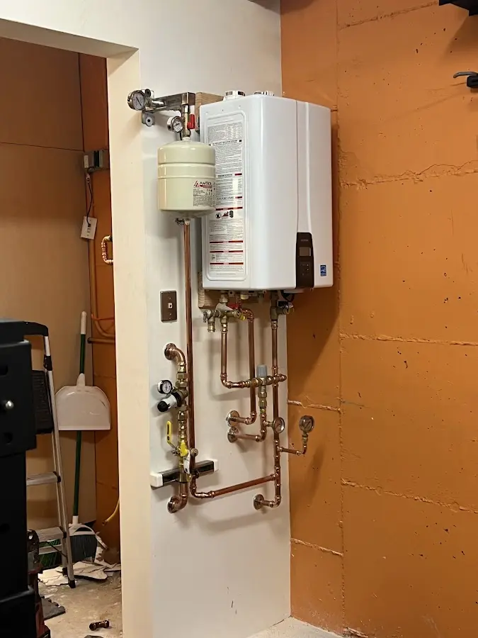 Plumbing technician inspecting water heater connections in Brookfield